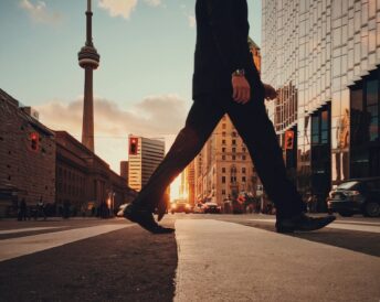 man walking in front of the CN tower in Toronto.