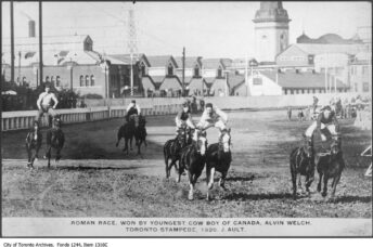 Item consists of a photograph showing cowboys engaged in trick horse-riding. The race was "won by youngest cow boy of Canada, Alvin Welch."